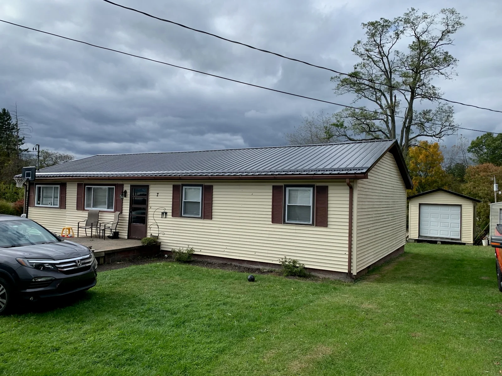 Standing seam metal roof on vinyl-sided residential home with proper flashing and trim
